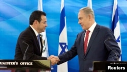 Presiden Guatemala Jimmy Morales dan Perdana Menteri Israel Benjamin Netanyahu berjabat tangan saat menyampaikan pernyataan ke media setelah pertemuan di Yerusalem, 29 November 2016. 