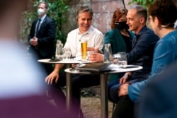 Secretary of State Antony Blinken, left, and German Minister of Foreign Affairs Heiko Maas are served beers as they arrive to speak at a youth outreach event at the Clarchens Ballhaus in Berlin, June 24, 2021.