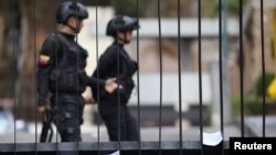 Members of Venezuelan security forces are seen on the background as documents regarding a proposed amnesty law for members of the military, police and civilians stand in a fence in Caracas, Venezuela, January 27, 2019.