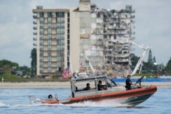 A Coast Guard boat patrols in front of the partially collapsed Champlain Towers South condo building, ahead of a planned visit to the site by President Joe Biden, on Thursday, July 1, 2021, in Surfside, Fla. (AP Photo/Mark Humphrey)