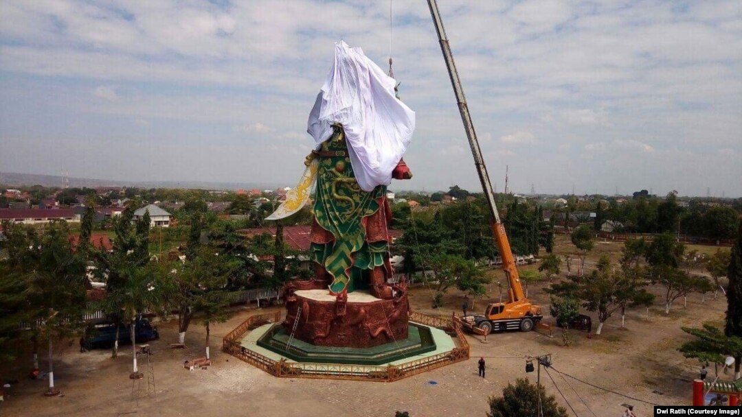 Workers cover the statue of the Chinese warrior god known variously as Kwan Sing Tee Koen, Kwan Kong, Kuan-Ti or Guan-Yu, in Tuban, East Java.