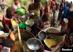 FILE - Congolese refugees, displaced by fighting between the Congo army and rebel group Allied Democratic Forces (ADF) last week, gather to collect food at the Bukanga transit camp in Bundibugyo town camp, 376km (238 miles) southwest of Kampala, July 17, 2013.