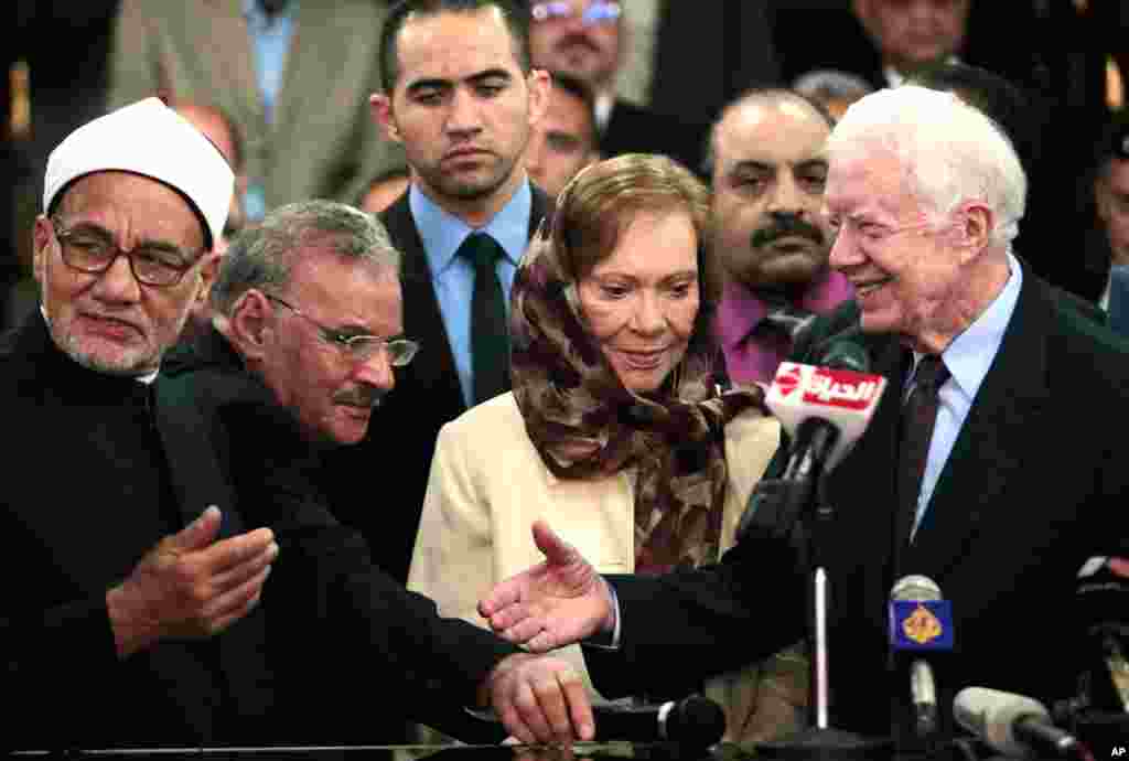 Former U.S. President Jimmy Carter (R) shakes hands with an official from Al-Azhar, a Sunni Muslim centre of learning, in Cairo May 24, 2012. Carter is in Egypt as part of the mission of his Carter Center to monitor presidential elections held on May 23 a