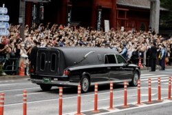 A vehicle carrying the body of the late former Japanese Prime Minister Shinzo Abe leaves Zojoji Temple in Tokyo, Japan, after his funeral on July 12, 2022. Abe was shot while campaigning for a parliamentary election. (Issei Kato/Reuters)