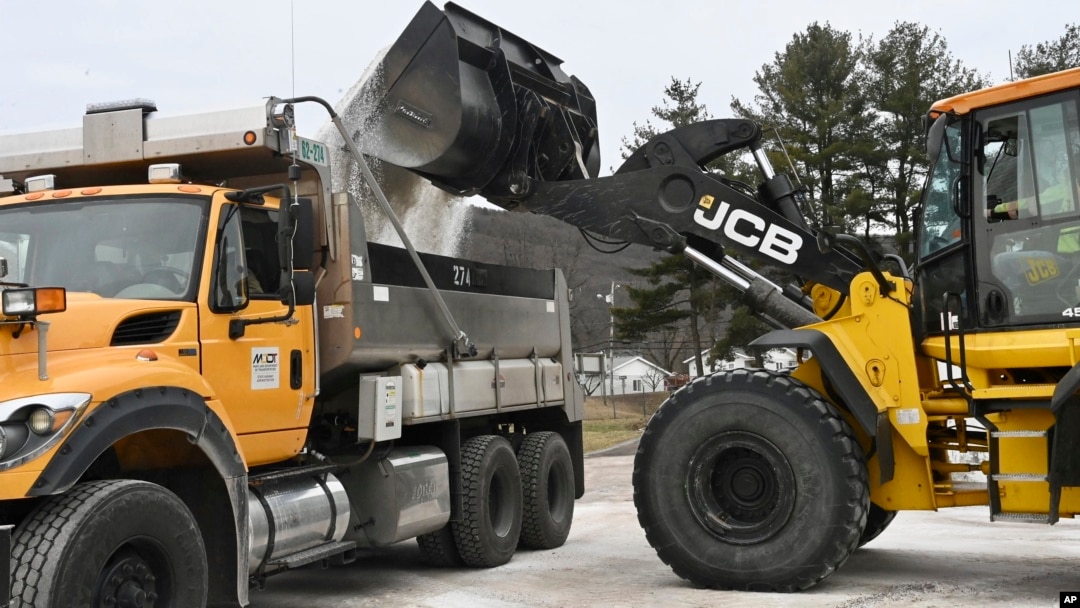 FILE - Maryland Department of Transportation employees use a backhoe to load a truck with salt in LaVale, Md., Feb. 5, 2025.