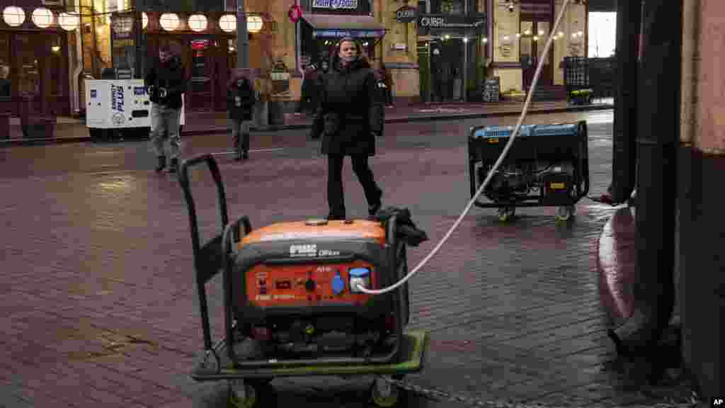 People locomotion  connected  a thoroughfare  with galore  businesses powered by generators during a blackout successful  Kyiv, Ukraine.