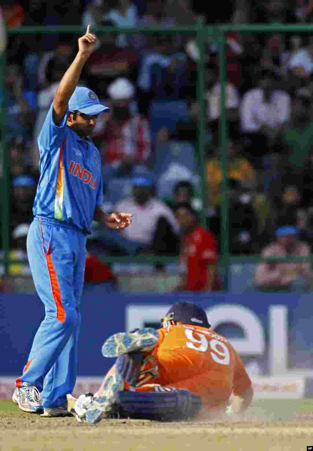 India's Gautam Gambhir celebrates the run out of the The Netherlands' Tom de Grooth (bottom) during their ICC Cricket World Cup group B match in New Delhi March 9, 2011. REUTERS/Adnan Abidi (INDIA - Tags: SPORT CRICKET)