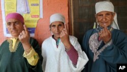 Kashmiri women display the indelible ink mark on their fingers after casting their votes, outside a polling station in Sheeri, about 60 kilometers (37 miles) north of Srinagar, India, May 7, 2014.