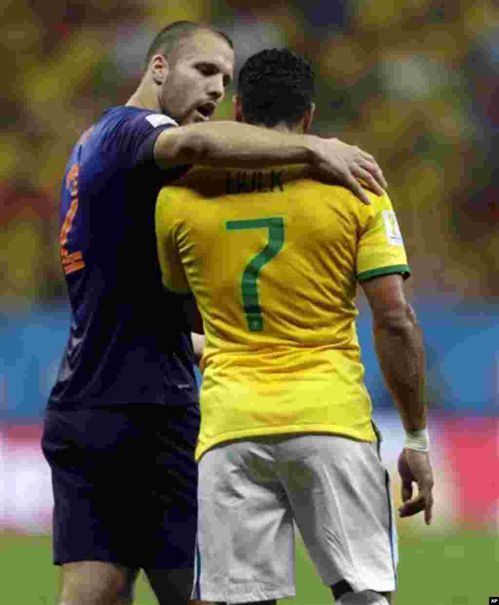 Netherlands' Ron Vlaar talks with Brazil's Hulk during the World Cup third-place soccer match between Brazil and the Netherlands at the Estadio Nacional in Brasilia, Brazil, Saturday, July 12, 2014. The Netherlands defeated Brazil 3-0. (AP Photo/Andre Pe