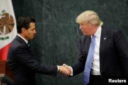FILE - U.S. Republican presidential nominee Donald Trump and Mexico's President Enrique Pena Nieto shake hands at a press conference at the Los Pinos residence in Mexico City, Mexico, Aug. 31, 2016.