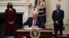 조 바이든 대통령이 21일 카멀라 해리스 부통령과 앤서니 파우치 국립 알레르기·전염병연구소 소장이 지켜보는 가운데 코로나바이러스 방역 관련 행정명령에 서명하고 있다.