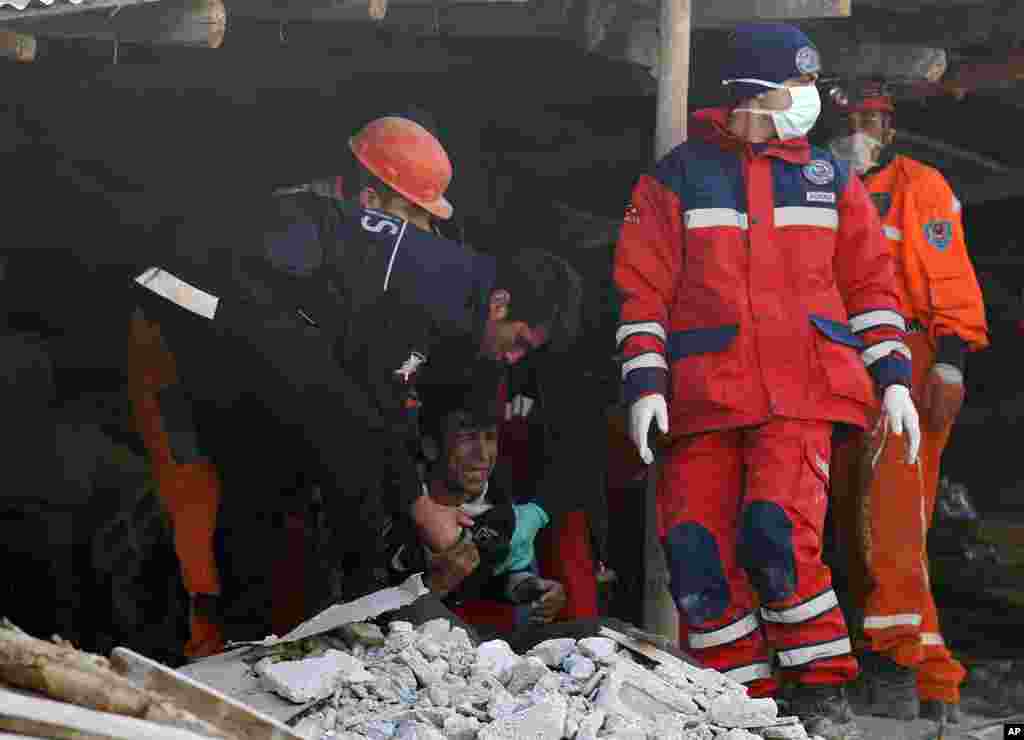 Rescue workers comfort a man who lost his relative after an earthquake in Ercis, near the eastern Turkish city of Van, early October 24, 2011. (Reuters)
