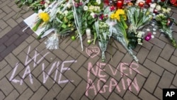 Un homme écrit "la vie, never again" avec de la craie près de la station de métro de Maelbeek, Bruxelles, 24 mars 2016. 