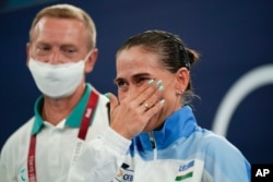 Oksana Chusovitina of Uzbekistan wipes away a tear after competing in vault during the women's artistic gymnastic qualifications at the 2020 Summer Olympics in Tokyo, July 25, 2021.