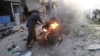 A man tries to put out a fire after a car bomb exploded in Tal Abyad, Syria, Friday, Nov. 2, 2019. 