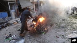 ဆီးရီးယားတွင် ကားဗုံးပေါက်ကွဲပြီးနောက် မီးငြှိမ်းသတ်ရန် ကြိုးစားနေသည့် အမျိုးသားတဦး။ (နိုဝင်ဘာ ၂၊ ၂၀၁၉)