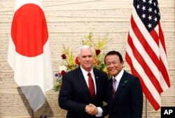 ຮອງປະທານາທິບໍດີ Mike Pence, ຊ້າຍ, ຮອງນາຍົກລັດຖະມົນຕີຍີ່ປຸ່ນ ແລະລັດຖະມົນຕີກະຊວງການເງິນ ທ່ານ Taro Aso ຖ່າຍຮູບຮ່ວມກັນ ຫຼັງຈາກເສັດສິ້ນກອງປະຊຸມຖະແຫຼງຂ່າວ ທີ່ທຳນຽບນາຍົກລັດຖະມົນຕີ ທີ່ ໂຕກຽວ, 18 ເມສາ, 2017