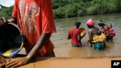 Des villageoises recherchent des pépites d’or dans les déchets provenant d'une station de lavage dans le village de Hamdalaye, Mali, 25 octobre 2007. 