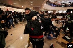 Plainclothes police officers arrest protesters in a mall during Christmas Eve in Hong Kong, Dec. 24, 2019.