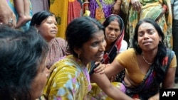 An Indian widow (C) is comforted by relatives and friends after the death of her husband on the outskirts of Patna, on May 12, 2015, after a new 7.3 earthquake and several powerful aftershocks hit neighbouring devastated Nepal. 