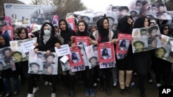 Women march in the Afghan capital of Kabul on Wednesday, Nov. 11, 2015 with pictures showing ethnic Hazaras who were allegedly killed by the Taliban, calling for a new government that can ensure security in the country. 