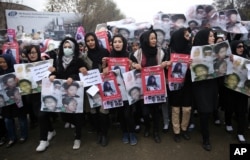 FILE - Women march in the Afghan capital of Kabul on Wednesday, Nov. 11, 2015 with pictures showing ethnic Hazaras who were allegedly killed by the Taliban, calling for a new government that can ensure security in the country.