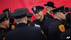 Matias Ferreira (center) celebrates with his colleagues during their graduation from the Suffolk County Police Department Academy in Suffolk, N.Y., March 24, 2017. Ferreira, a former U.S. Marine Corps lance corporal who lost his legs below the knee when he stepped on a hidden explosive in Afghanistan in 2011, is joining a suburban New York police department.