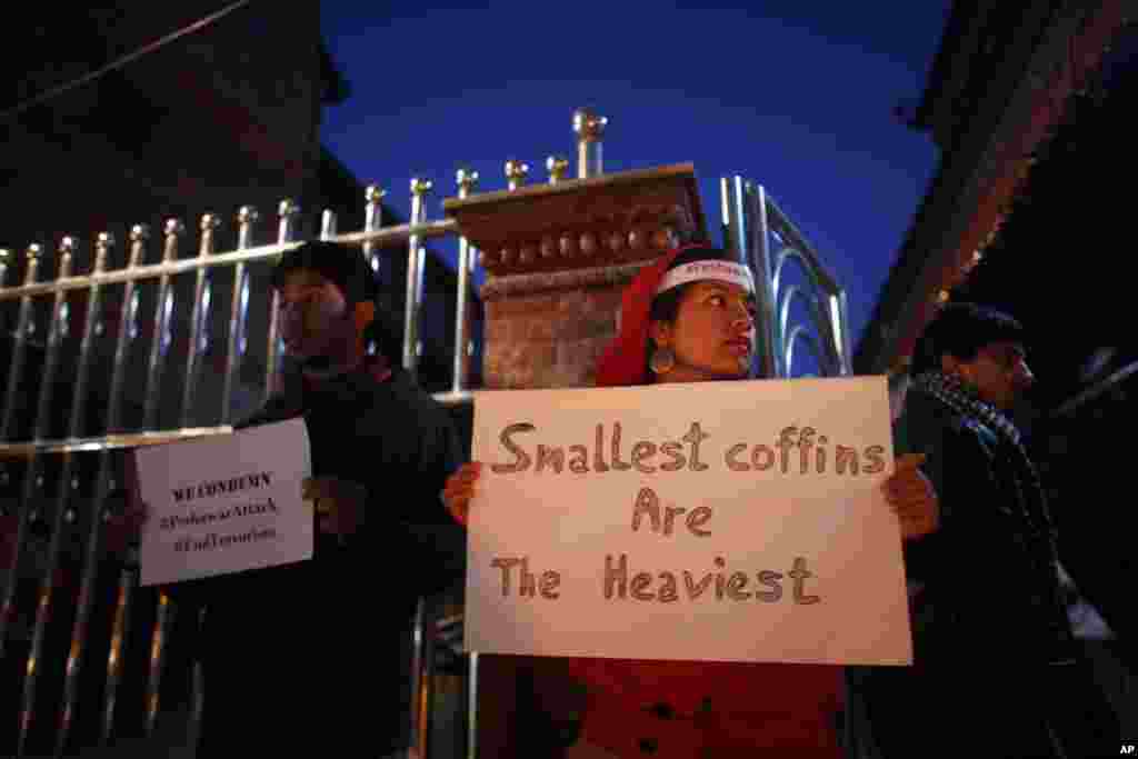 A Nepalese youth group hold placards at a candlelight vigil for the victims of the Taliban attack in Peshawar, in Katmandu, Nepal, Dec. 17, 2014.