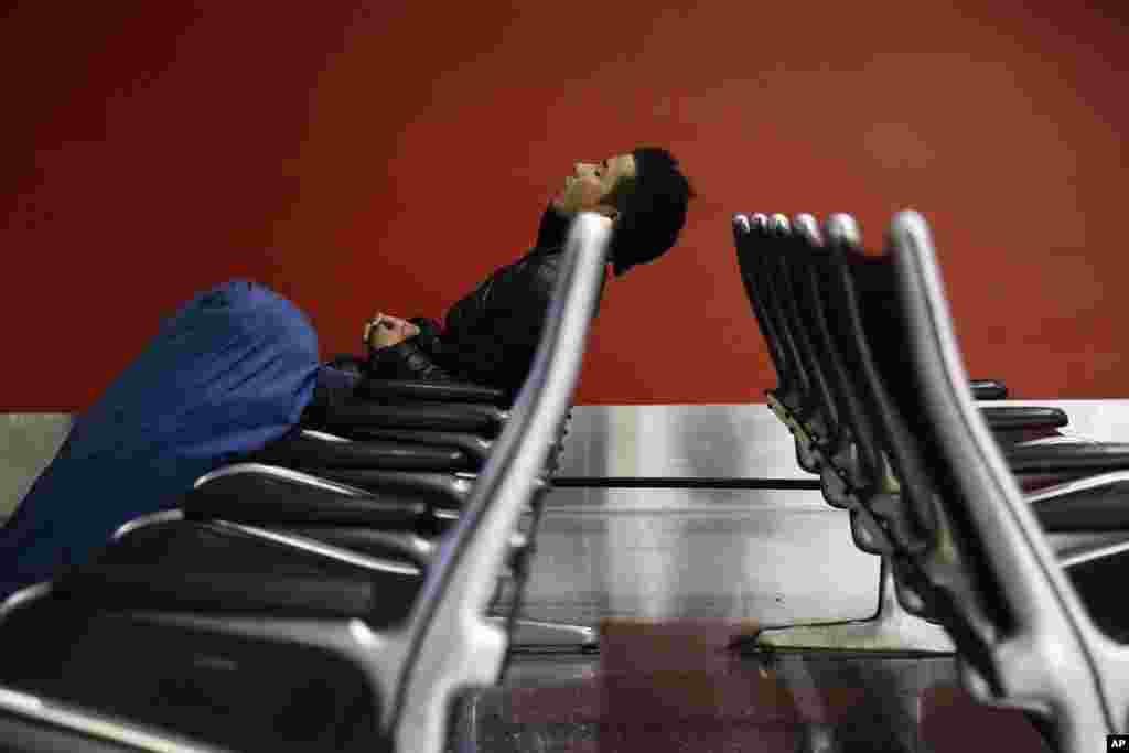 A man sleeps at the Los Angeles International Airport, Nov. 27, 2013, in Los Angeles. More than 43 million people are to travel over the long holiday weekend, according to AAA.