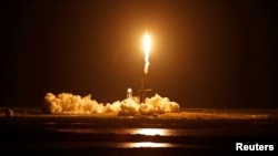 Un cohete Falcon 9 de SpaceX ilumina la noche en Cabo Cañaveral, Florida, al despegar del Centro Espacial Kennedy con una tripulación "turística" sin astronautas profesionales el 15 de septiembre de 2021.