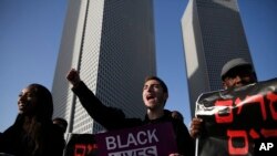 People holds banners as they protest against Israeli police and demand the appointment of an investigating judge to probe the killing of Yehuda Biadga, a mentally ill Ethiopian-Israeli, by Israeli police, in Tel Aviv, Israel, Wednesday, Jan. 30, 2019.