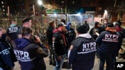 Des policiers se rassemblent après avoir appréhendé des suspects lors d'un raid dans l'arrondissement de Brooklyn à New York, mardi 4 janvier 2022. 