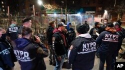 Polisi kota New York (NYPD) berkumpul setelah menangkap tersangka dalam penggerebekan di wilayah Brooklyn di New York, Selasa, 4 Januari 2022.(AP Photo/Seth Wenig)