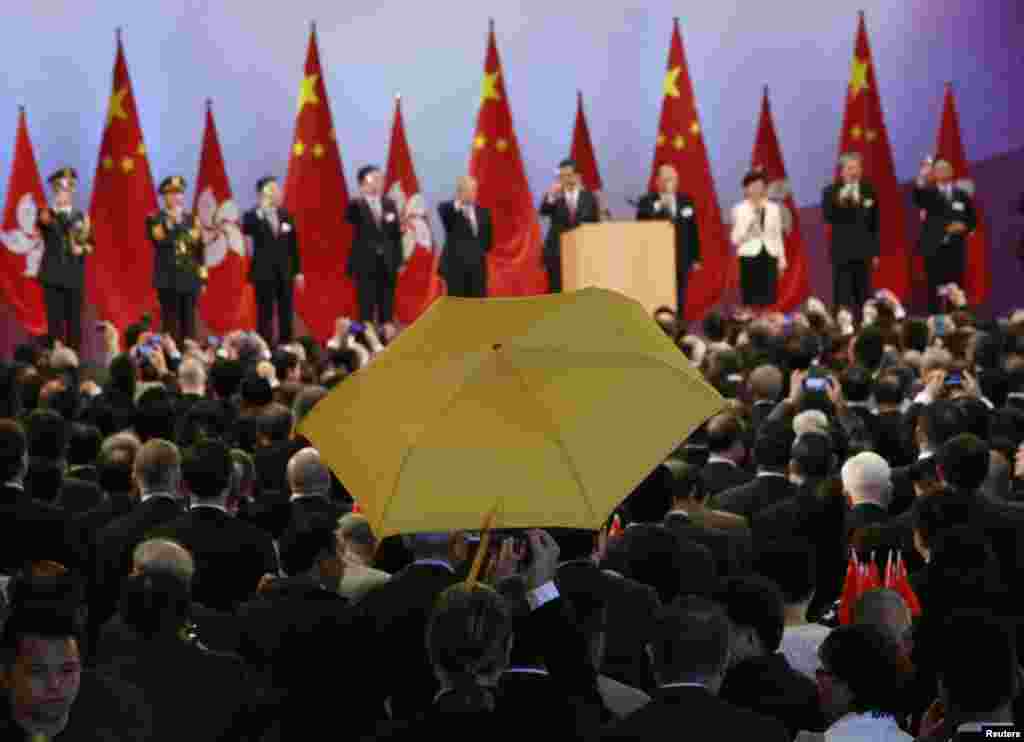 Paul Zimmerman, a district councilor, raises a yellow umbrella as Hong Kong Chief Executive Leung Chun-ying (5th R) and other officials make a toast to guests at a reception following a flag-raising ceremony in Hong Kong, celebrating the 65th anniversary of China National Day. 
