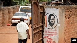 In this Thursday, Sept. 20, 2018 file photo, a man walks past graffiti in support of pop star-turned-opposition lawmaker Bobi Wine, whose real name is Kyagulanyi Ssentamu, in the Kamwokya neighborhood where he has many supporters.