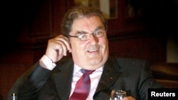 FILE - Former Social Democratic and Labour Party (SDLP) leader John Hume sits with a drink after announcing at a news conference in Belfast, that he will not be standing again for the European Parliament, Feb. 4, 2004.