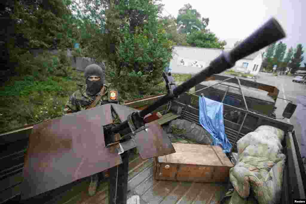 An armed pro-Russian separatist from the so-called Vostok (East) Battalion stands guard at a checkpoint in the eastern Ukrainian city of Donetsk July 8, 2014.