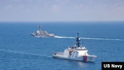 美国海军公布的图片显示美国海军“基德”号阿利·伯克级导弹驱逐舰与美国海岸警卫队“蒙罗”号传奇级巡逻舰在当地时间2021年8月27日例行穿越台湾海峡的国际水域。