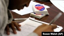 FILE - A student fills out a college enrollment application. 