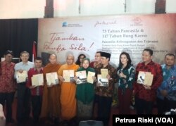 Wakil Ketua MPR RI Ahmad Basarah, Wali Kota Surabaya Tri Rismarini, dan sejumlah tokoh agama dan kepercayaan di Surabaya menerima perangko tulisan tangan Bung Karno pada Peringatan Hari Lahir Bung Karno dan Hari Lahir Pancasila, Surabaya, Rabu, 6 Juni 2018. (Foto: Petrus Riski/VOA)