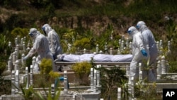 Workers wearing personal protective equipment (PPE) carry the body of a victim of the coronavirus disease at a Muslim cemetery in Gombak, outskirts of Kuala Lumpur, Malaysia, Feb. 5, 2021.
