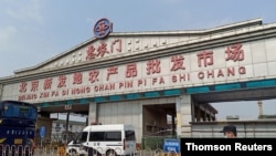 Police officer wearing a face mask is seen outside an entrance of the Xinfadi wholesale market, which has been closed for business after new coronavirus infections were detected, in Beijing, on June 13, 2020.