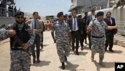 Italian Interior Minister Matteo Salvini, center,visits the Tripoli naval base, in Tripoli, Libya, June 25, 2018.