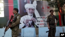 សន្តិសុខ​អាហ្វហ្គានីស្ថាន​ឈរ​យាម​នៅ​ខាង​មុខ​កន្លែង​ដែល​មាន​បិទ​រូប​លោក Ashraf Ghani បេក្ខជន​ប្រធានាធិបតី នៅ​ទីក្រុង​កាប៊ុល ប្រទេស​អាហ្វហ្គានីស្ថាន កាល​ពី​ថ្ងៃ​ទី​២៣ កញ្ញា ២០១៩។