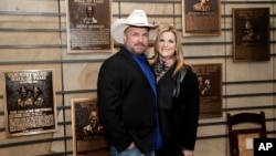 FILE - Country music stars Garth Brooks and Trisha Yearwood, married since 2005, pose in the Country Music Hall of Fame, March 27, 2018, in Nashville, Tenn. 
