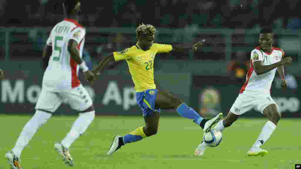 Didier Ibrahim Ndong du Gabon, au centre, se défend contre Jonathan Zongo du Burkina Faso, à droite, lors du match de football de la Coupe d&#39;Afrique des Nations Groupe A entre le Burkina Faso et le Gabon à Bata, en Guinée équatoriale, samedi 17 janvier 2015.