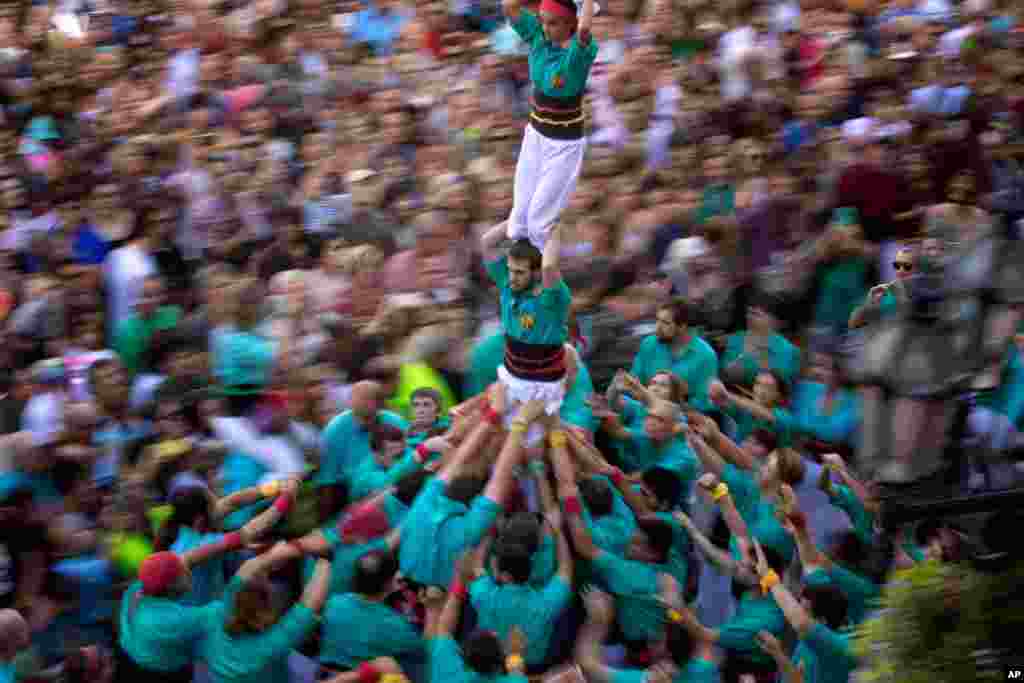 Participants walk maintaining a human tower or &quot;Castellers&quot; during the Saint Merce celebrations in San Jaume square in Barcelona, Spain.
