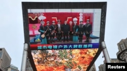 A giant screen shows news footage of Chinese President Xi Jinping visiting Xinjiang Uyghur Autonomous Region, at a shopping center, in Beijing, on July 15, 2022. (Tingshu Wang/Reuters)