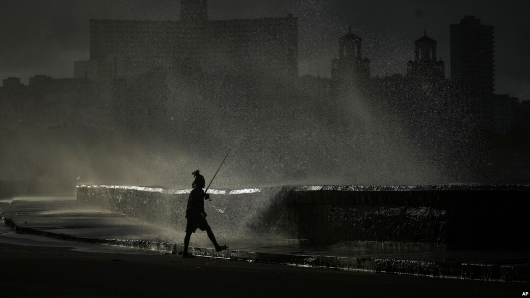 A person fishes along the boardwalk as waves crash in Havana, Oct. 21, 2024.
