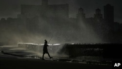 A person fishes along the boardwalk as waves crash in Havana, Oct. 21, 2024.